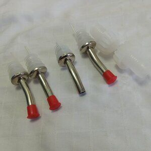 Four metal spouts (miss one cap) and two clear plastic caps
